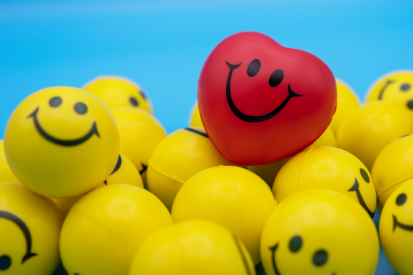 Yellow plastic smiley faces with a red heart smiling
