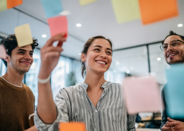 People working together and putting sticky notes on a board