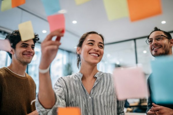 People working together and putting sticky notes on a board
