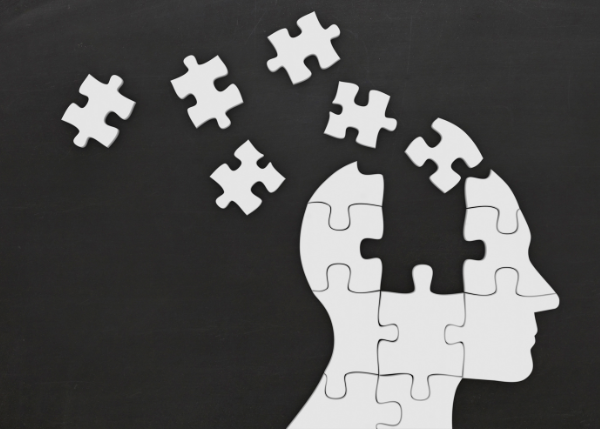 Outline of a head made up of puzzle pieces that are coming together