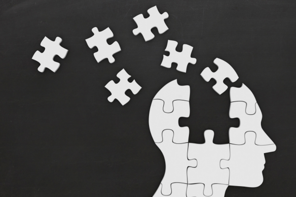 Outline of a head made up of puzzle pieces that are coming together