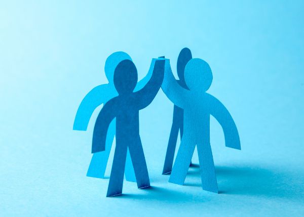 Paper cutouts of people giving each other high fives