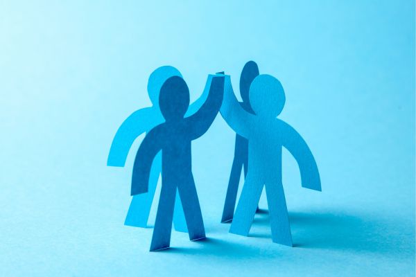 Paper cutouts of people giving each other high fives