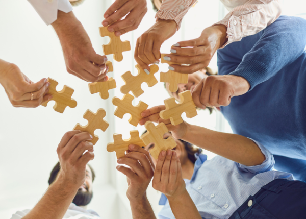 Team putting puzzle pieces together 