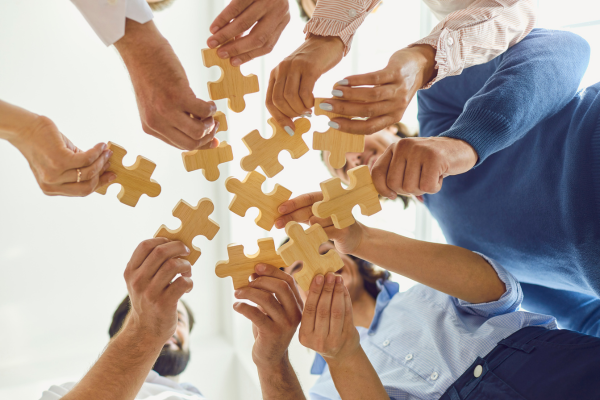 Team putting puzzle pieces together 